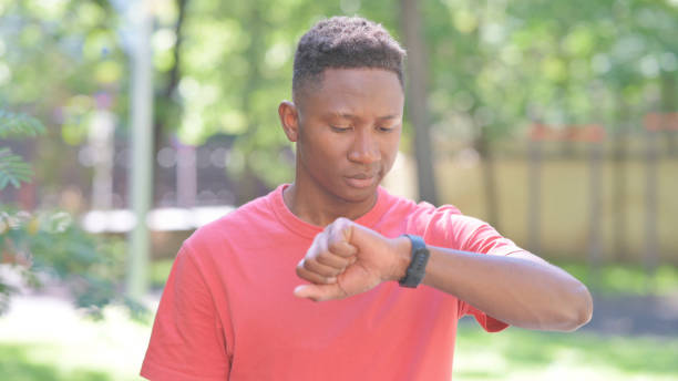 istock Waiting Casual African Man Checking Time on Wrist Watch 2167318344