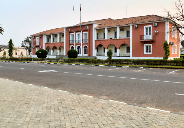 Luena (Luso), Moxico province, Angola: Moxico Provincial Government headquarters, Portuguese colonial building in 'Estado Novo' architecture style - Moxico is the largest province in Angola, almost as big as Romania. Moxico located in the eastern part of the country and bordered by Zambia to the east. It is characterized by vast, sparsely populated landscapes dominated by dense forests, savannas, and numerous rivers, including the Zambezi, which originates in the province. Moxico's economy is largely driven by agriculture, forestry, and fishing, with the province's rich natural resources offering potential for development. Despite its size, Moxico remains one of Angola's less developed regions, with infrastructure challenges that have been exacerbated by the legacy of the civil war. The province is home to a diverse population with various ethnic groups, each maintaining distinct cultural practices and languages. Moxico also has significant ecological importance, with protected areas that are home to diverse wildlife, contributing to conservation efforts in Angola.