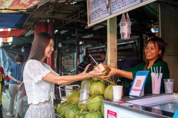 Tourist buying coconut water at market stall