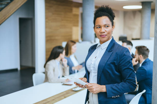 istock Professional holding tablet with meeting in background 2167322792