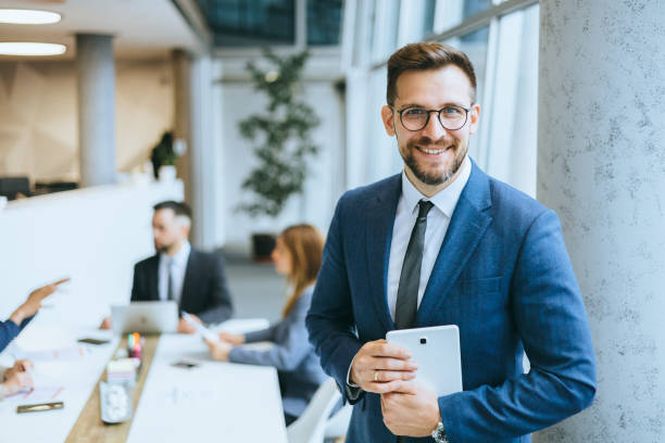 istock A smiling male executive with digital tablet 2167322804