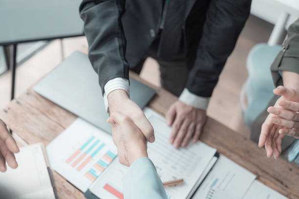 istock Businessmen holding hands having documents with graphs and financial charts, concept of business agreement together, close-up image. 2167325214
