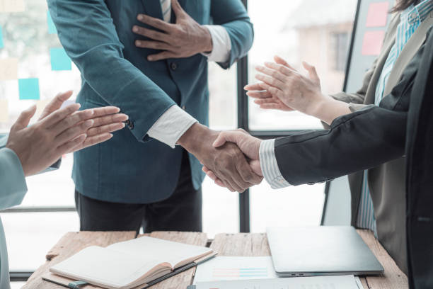 istock Businessmen holding hands having documents with graphs and financial charts, concept of business agreement together, close-up image. 2167325215
