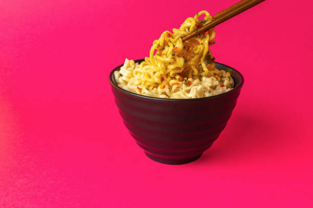 istock Vibrant Noodle Bowl: Delicious Instant Ramen with Chopsticks on Eye-Catching Pink Background 2167332868