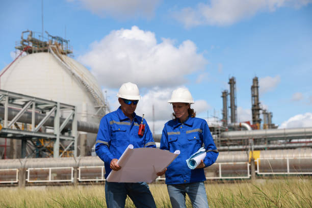 istock Two maintenance engineers use blueprint to perform inspections and track work progress. Maintenance near gas storage tanks 2167333732