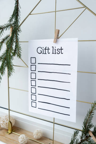 istock Holiday preparation paper note with GIFT LIST checklist text. Vision board with cozy minimalistic handmade new year Christmas decor Low key festive celebration 2167337237