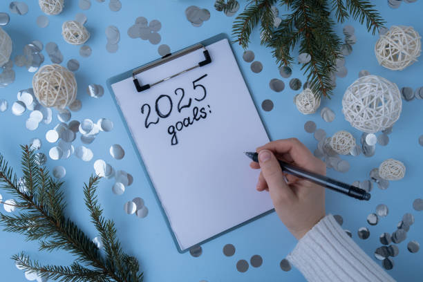 istock Female hands writing handwritten 2025 GOALS new year resolutions aims goals on paper notepad. Preparation for New Year. Planning and setting goals for personal development 2167337870