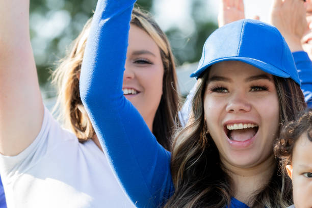 istock Woman cheers in stands while attending college sporting event 2167337963