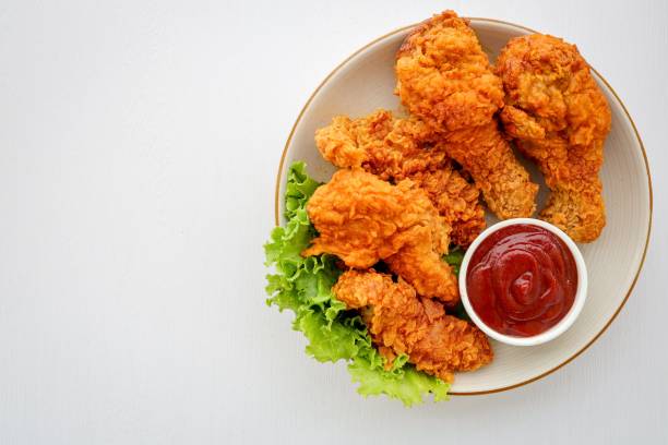 istock Crispy Fried chicken in a white plate with tomato sauce on white background table 2167338189