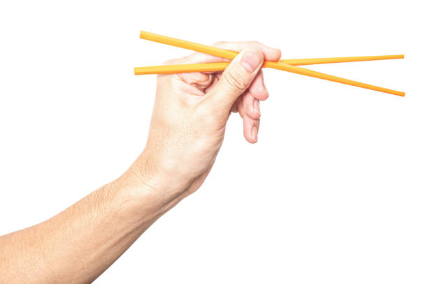 istock Male hand holding a orange plastic chopstick isolated on white background. 2167342600