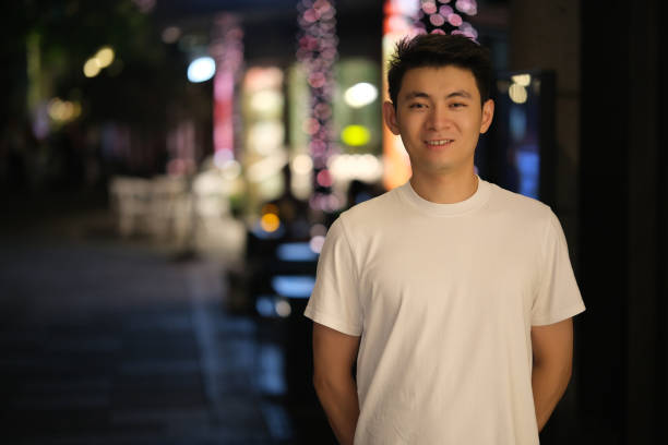 istock Cute Chinese young man smiling, front portrait at night 2167344672