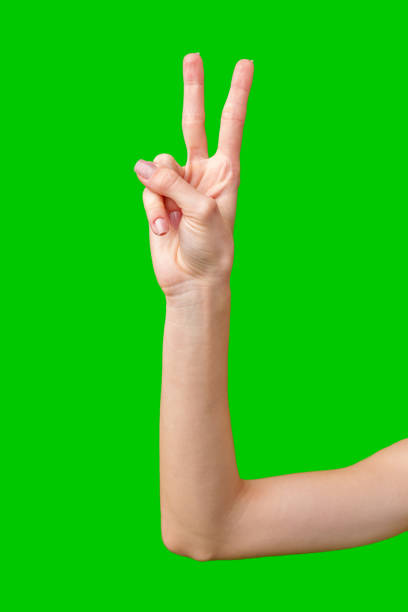 istock Woman's Hand Making the Peace Sign Against a Green Screen 2167348259