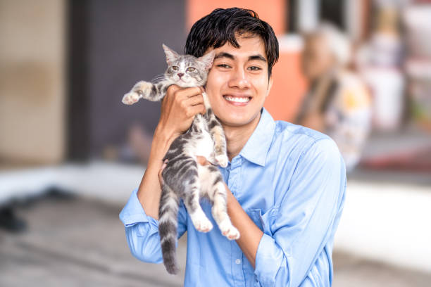 istock a guy smiling while hugging his cat. Handsome men and a cute kitten 2167349463