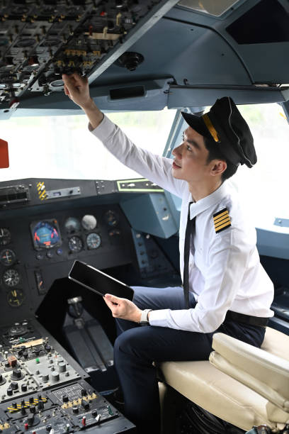 istock Pilot sitting in the cockpit of an airplane and adjusting controls on the overhead panel 2167350968