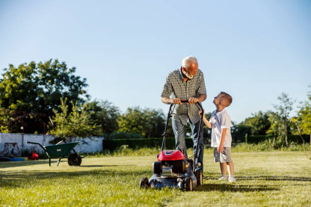 istock Granddad and his grandson mowing lawn in backyard. Teamwork concept. 2167351708