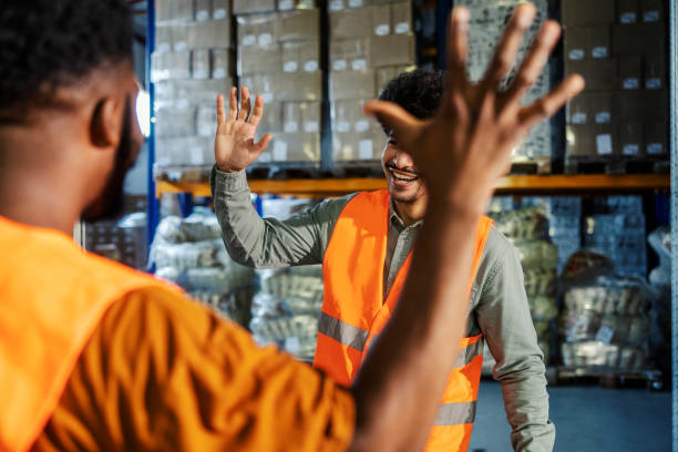 istock Diverse supervisor and warehouse worker greeting and preparing to clap hands. Team of experienced workers collaborating 2167352457