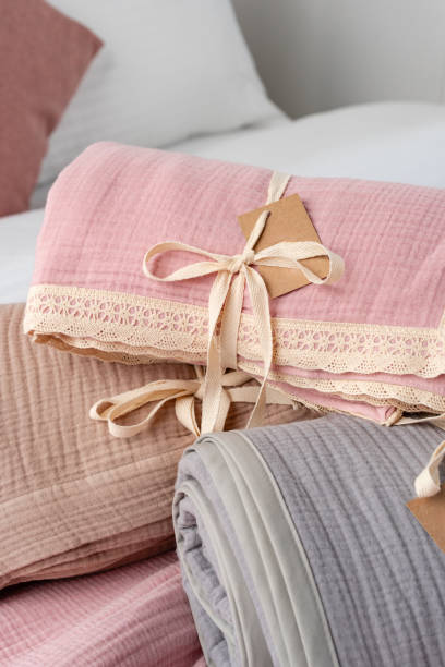 istock Rolled Up Soft Pink and Grey Muslin Blankets on Bed 2167352499