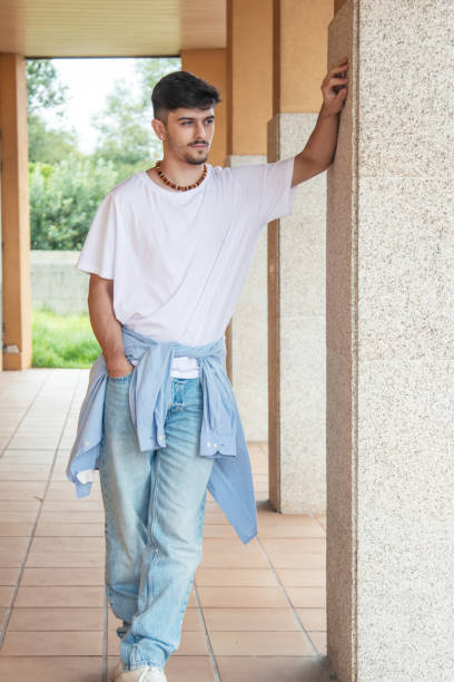 modern young man posing on the wall on the street