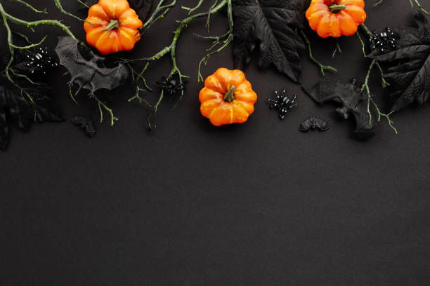 istock Halloween decorations on dark background. Flat lay composition with pumpkins, branches with bats, spiders. 2167357174