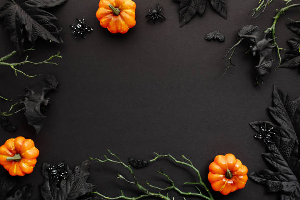 istock Modern Halloween background with pumpkins, branches with bats, spiders decorations on black. Flat lay, top view, copy space. 2167357425