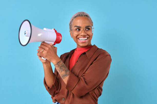 Joyful individual with a megaphone against a vibrant blue background