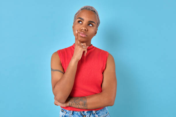 istock Thoughtful woman reflecting in front of a bright blue backdrop 2167358770