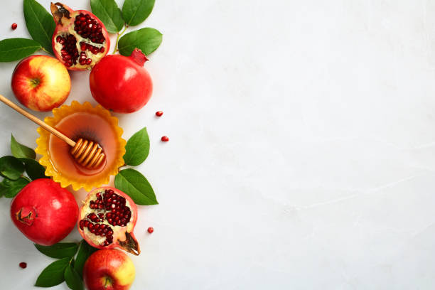istock Flat lay composition with Rosh Hashanah holiday attributes on stone background. Top view honey, pomegranate, apples and green leaves. 2167358964