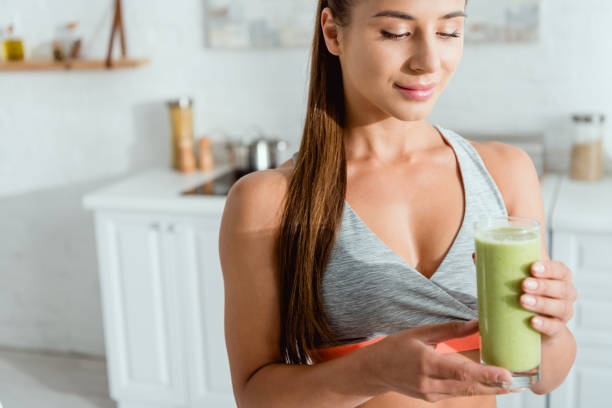 istock Fit young woman makes a healthy smoothie in a bright, fresh kitchen 2167358970