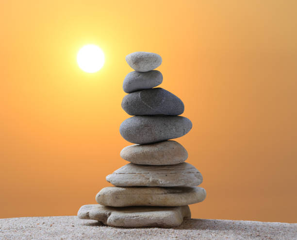 Stacked stones in a pyramid shape on a background on sunrise and copy space for design in your work, travel or zen theme.