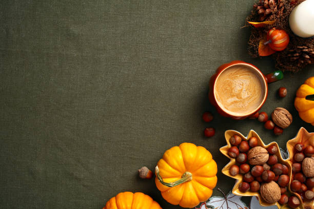 istock Autumn flat lay composition. Flat lay pumpkins, nuts in leaf-shaped plate, coffee cup, candle, acorns on green cloth table. Vintage style. Fall, Thanksgiving concept. 2167360671
