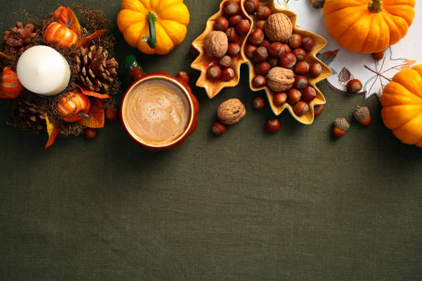 istock Autumn fall composition. Flat lay pumpkins, nuts in leaf-shaped plate, coffee cup, decorative candle with pine cones. Cozy, vintage style. 2167360834