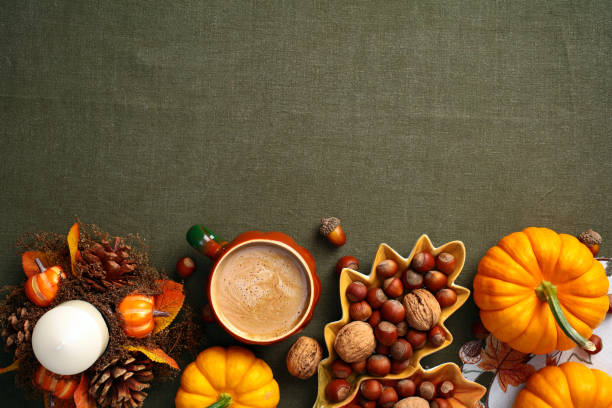 istock Still life pumpkins, acorns, candle, coffee cup, decorative leaf-shaped plate with nuts on green cloth table. Autumn, fall, Thanksgiving concept. Flat lay, top view. 2167361866
