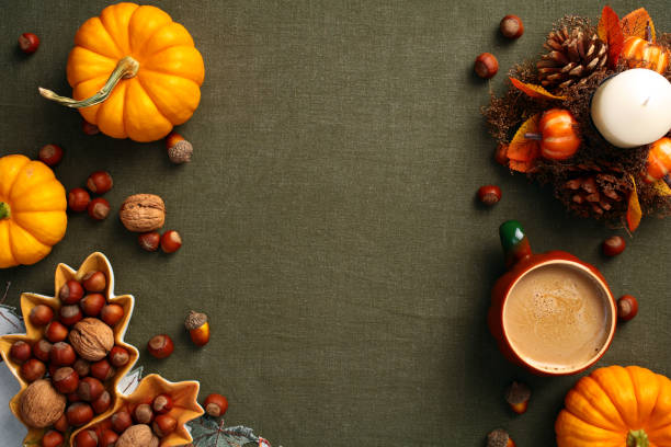 istock Vintage autumn flat lay composition with pumpkins, coffee cup, decorative candle, plate with nuts, acorns on green cloth on table. Top view, flat lay. 2167362044