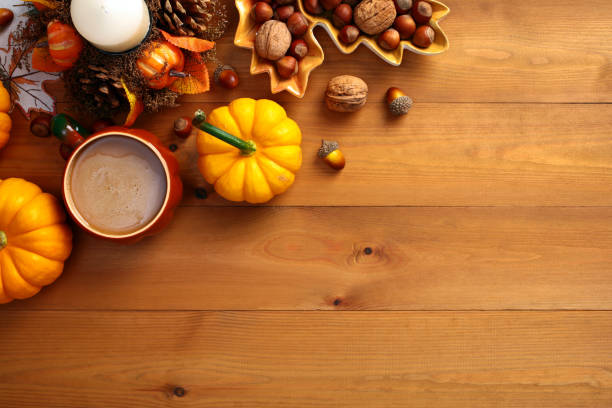 istock Autumn flat lay composition with pumpkins, coffee cup, nuts, acorns, candle on wooden surface. Autumn, fall, Thanksgiving concept. Top view. 2167362098