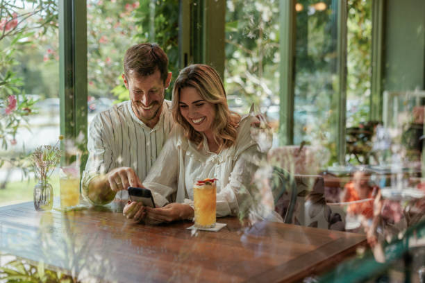 Couple laughing while looking at a smartphone