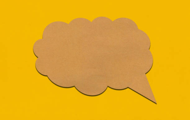 istock Brown paper speech bubble on yellow paper background. 2167365780