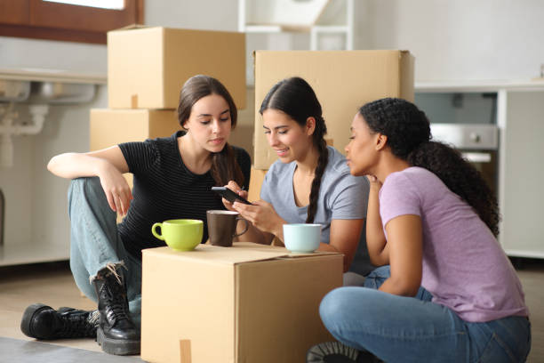 Three roommates drawing on smart phone moving house