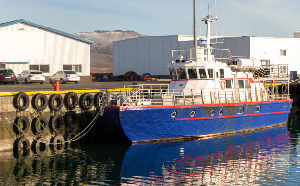 istock A blue boat is docked at a pier. The boat is surrounded by several large tires 2167366319