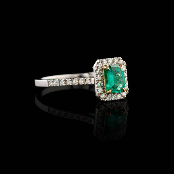 istock Beautiful white gold ring with diamonds and emerald on a black background 2167366777