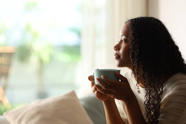 istock Black woman contemplating at home drinking coffee 2167367513