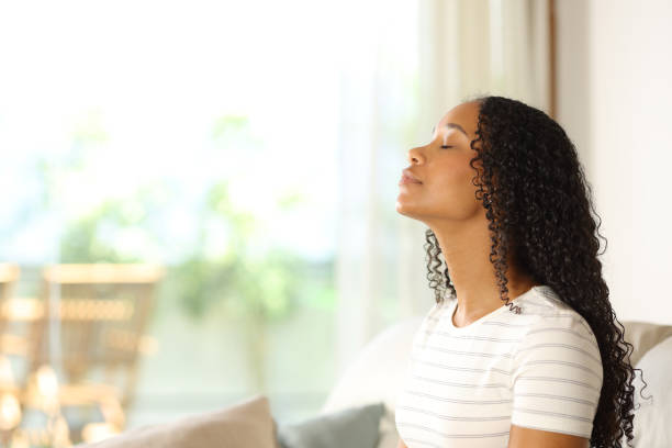 Black woman breathing at home and relaxing stock photo