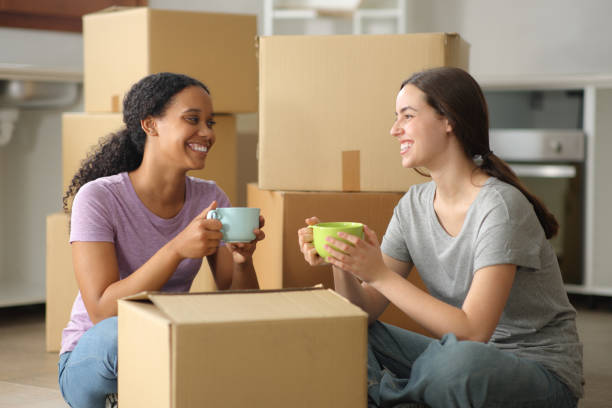 istock Interracial roommates talking and drinking moving home 2167367622