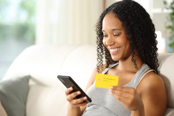 istock Happy black woman buying online using card at home 2167367672