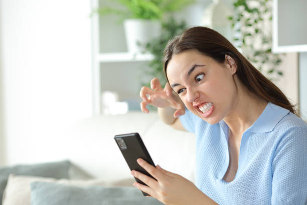istock Angry woman checking cell phone at home 2167367990