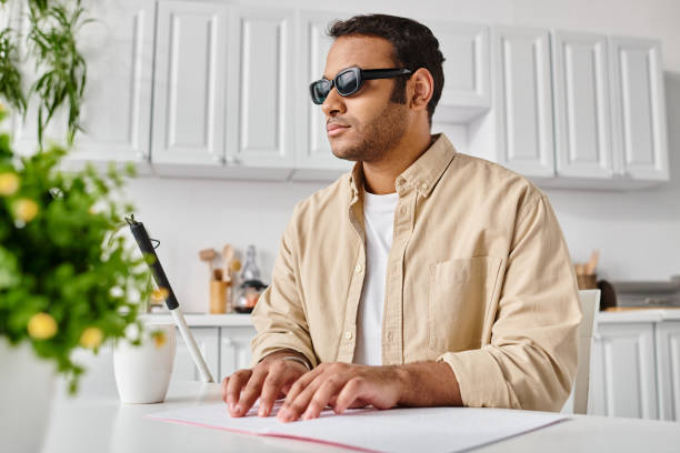 Young man with vision impairment engaged in creative work at a home office