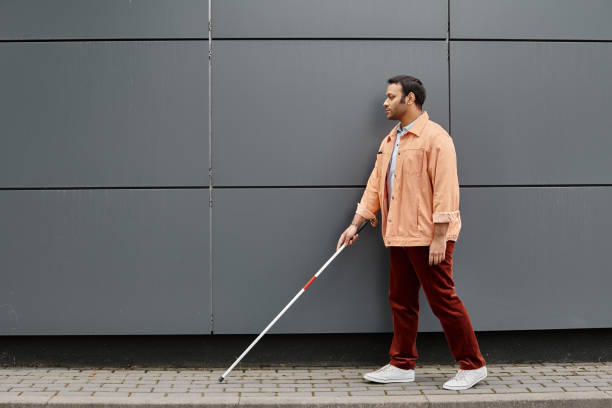istock A young man confidently navigating the city with a white cane on a sunny afternoon 2167368875