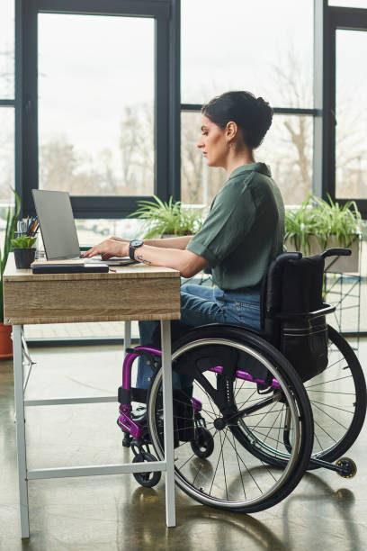 istock Dynamic professional in wheelchair engages with computer in modern office setup 2167369979