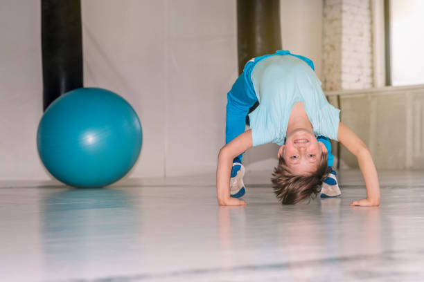 istock boy doing exercise bridge in the white fitness room 2167383817