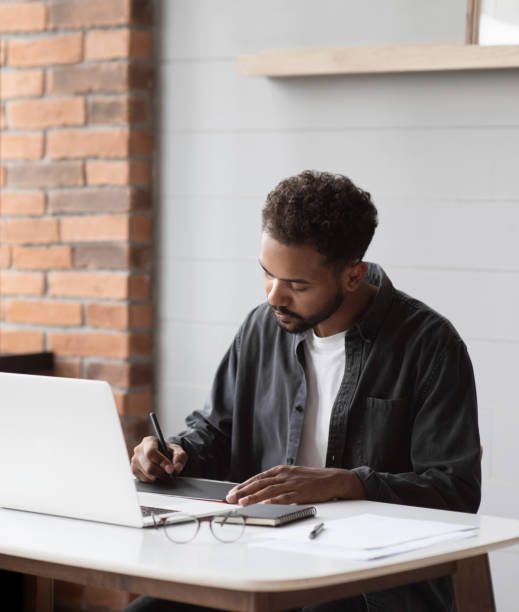 istock Man using laptop at home, designer working in office 2167385857
