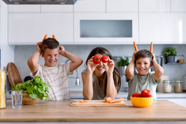 istock Fun with vegetables as family makes faces in kitchen. 2167387035